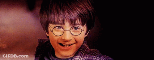 A Young Boy Wearing Glasses And A Plaid Shirt Is Smiling GIF