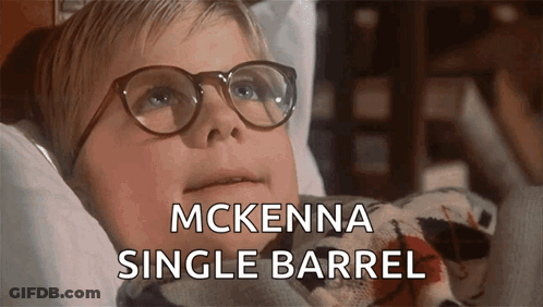 A Young Boy Wearing Glasses Is Laying In A Bed With The Words Mckenna Single Barrel Below Him GIF