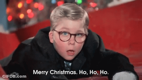 A Young Boy Wearing Glasses Is Laying On The Ground And Saying Merry Christmas . Ho , Ho , Ho . GIF