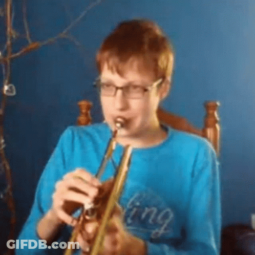 A Young Boy Wearing Glasses Is Playing A Trumpet . GIF