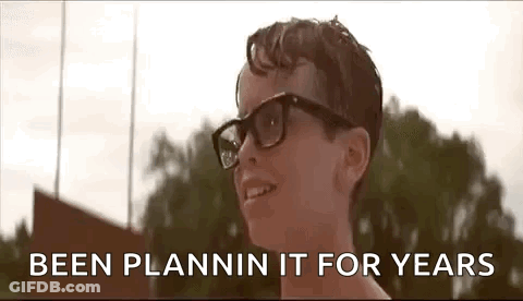 A Young Boy Wearing Glasses Is Smiling With The Words `` Been Plannin It For Years '' Behind Him . GIF