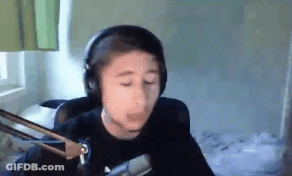 A Young Boy Wearing Headphones And A Microphone Is Making A Funny Face . GIF