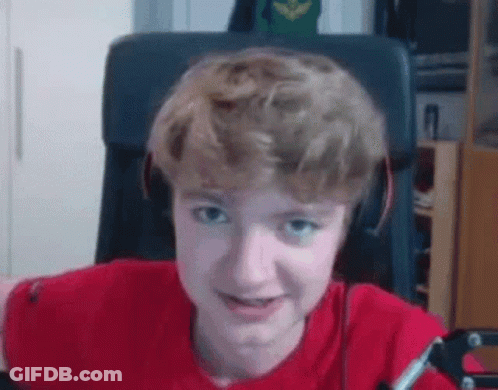 A Young Boy Wearing Headphones And A Red Shirt Is Sitting In A Chair And Making A Funny Face . GIF