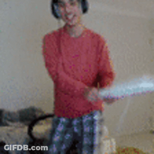 A Young Boy Wearing Headphones Is Holding A Pillow In His Hands GIF
