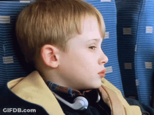 A Young Boy Wearing Headphones Looks To The Side GIF