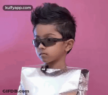 A Young Boy Wearing Sunglasses And A Foil Bag On His Head . GIF
