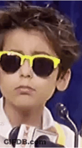 A Young Boy Wearing Sunglasses And A Microphone . GIF