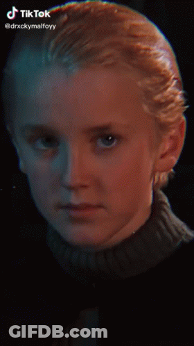 A Young Boy With Blonde Hair And A Nose Ring Is Smiling For The Camera . GIF