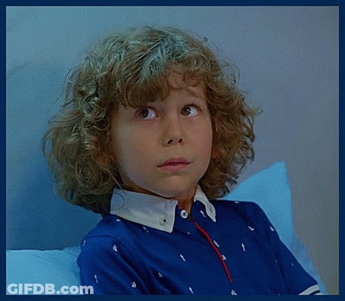A Young Boy With Curly Hair Wearing A Blue Shirt GIF
