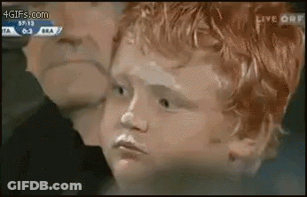 A Young Boy With Red Hair Is Being Kissed By A Man While Watching A Soccer Game . GIF