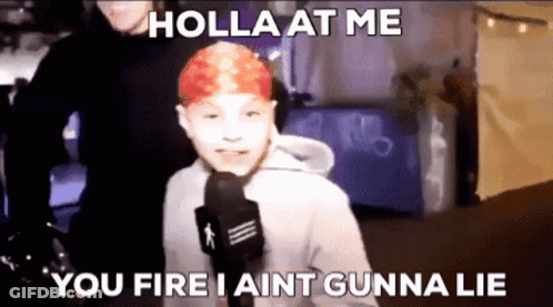A Young Boy With Red Hair Is Talking Into A Microphone . GIF