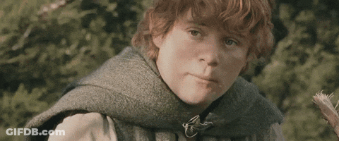 A Young Boy With Red Hair Is Wearing A Gray Vest And A Green Scarf . GIF