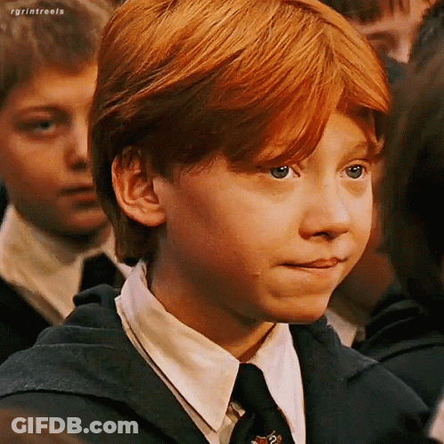 A Young Boy With Red Hair Is Wearing A Suit And Tie And Making A Face . GIF
