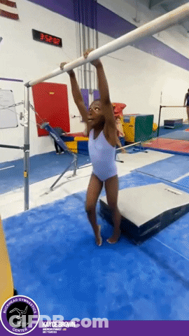 A Young Girl Hangs From A Bar In A Gym With Kayce Brown Written On The Bottom GIF