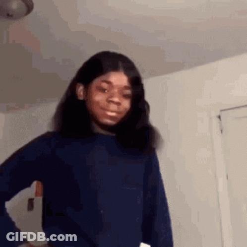 A Young Girl In A Blue Sweater Is Making A Funny Face . GIF