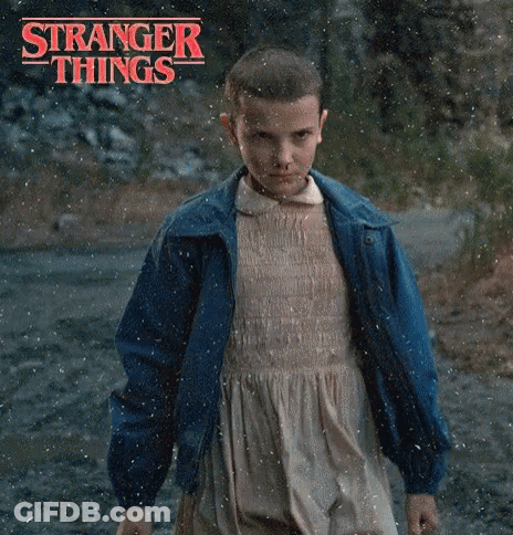 A Young Girl In A Dress And Blue Jacket Is Standing In The Rain . GIF