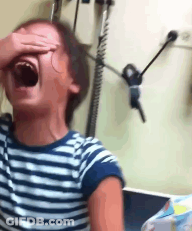 A Young Girl In A Striped Shirt Is Covering Her Face With Her Hand GIF