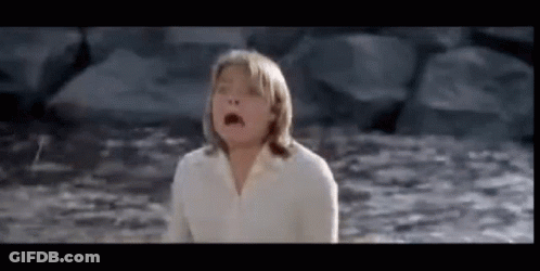 A Young Girl In A White Shirt Is Standing In The Water . GIF