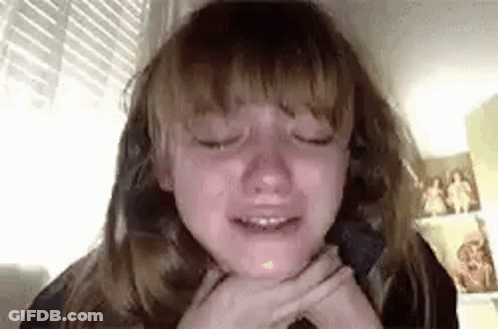 A Young Girl Is Crying While Sitting In A Chair With Her Eyes Closed . GIF