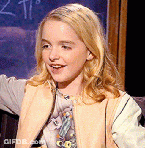 A Young Girl Is Smiling In Front Of A Blackboard With The Number 2 On It GIF