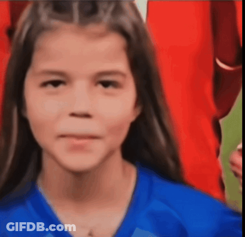 A Young Girl Wearing A Blue Shirt Is Smiling For The Camera GIF