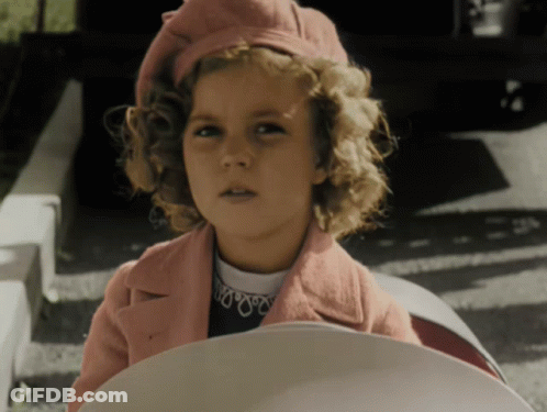 A Young Girl Wearing A Pink Coat And A Red Hat GIF
