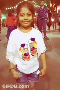 A Young Girl Wearing A White Shirt With A Picture Of Shoes On It GIF