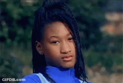 A Young Girl With Dreadlocks Is Wearing A Blue Turtleneck And Overalls GIF