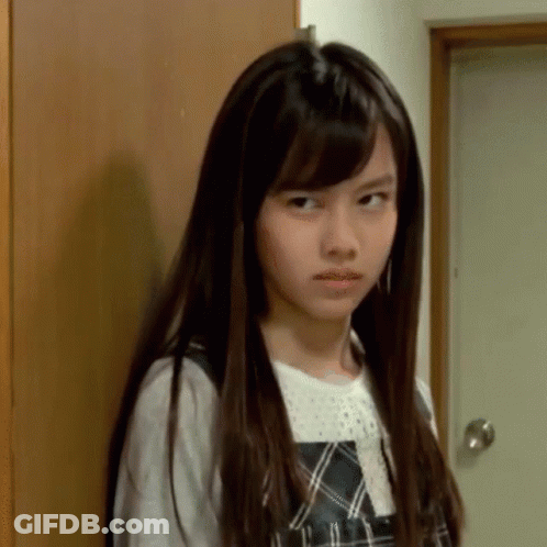 A Young Girl With Long Hair Is Making A Funny Face GIF