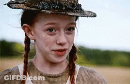 A Young Girl With Pigtails Wearing A Hat And A White Shirt . GIF