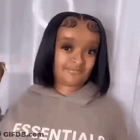 A Young Girl With Short Black Hair Is Wearing A Hoodie And Smiling . GIF