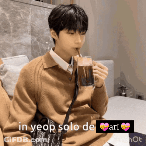 A Young Man Drinking From A Glass With A Straw And The Words In Yeop Solo De Ari Above Him GIF