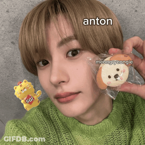 Young Man Holding Cookie With Anton On Face GIF