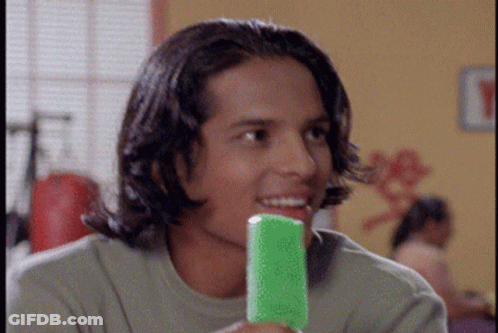 A Young Man Holding A Green Popsicle In His Mouth GIF