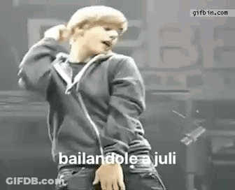 A Young Man In A Black Hoodie Is Dancing On A Stage In Front Of A Crowd . GIF