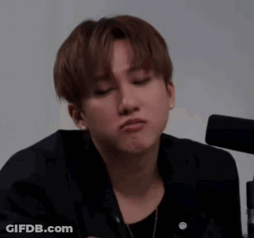 A Young Man In A Black Jacket Is Making A Funny Face With His Eyes Closed . GIF