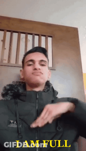 A Young Man In A Black Jacket Says I Am Full In Yellow Letters GIF