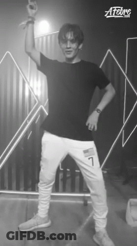 A Young Man In A Black Shirt And White Sweatpants With The Number 7 On The Side GIF