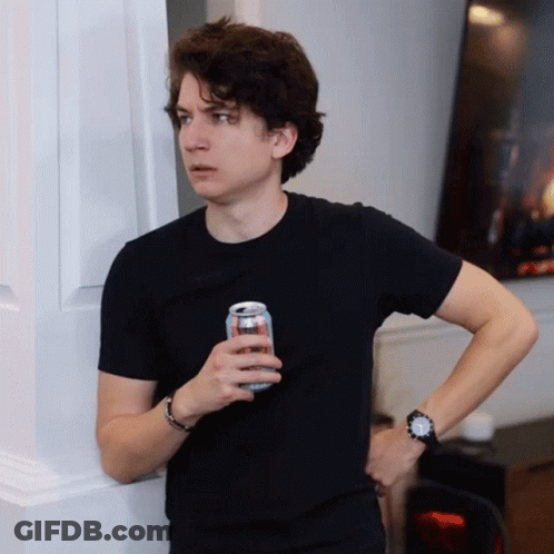 A Young Man In A Black Shirt Is Holding A Can Of Soda GIF