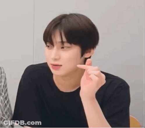 A Young Man In A Black Shirt Is Making A Funny Face While Making A Heart With His Finger . GIF