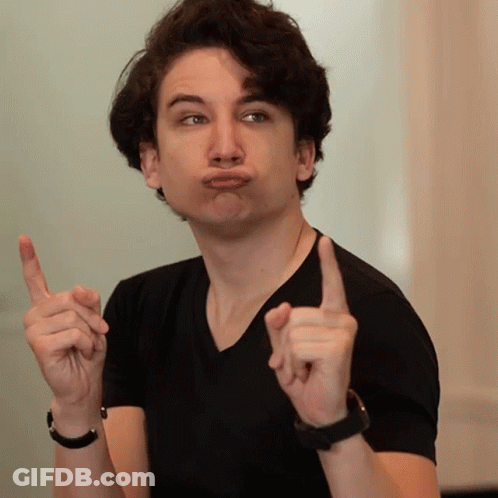 A Young Man In A Black Shirt Making A Funny Face With His Fingers GIF