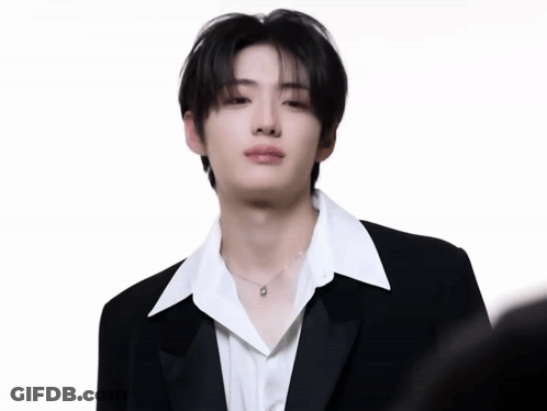 A Young Man In A Black Suit And White Shirt GIF