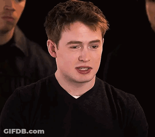 A Young Man In A Black Sweater Is Making A Funny Face . GIF