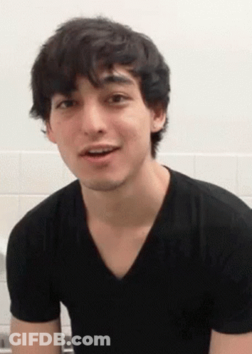 A Young Man In A Black T-Shirt Is Making A Funny Face . GIF