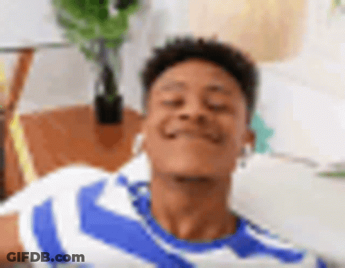A Young Man In A Blue And White Striped Shirt Is Laying On A Couch With His Eyes Closed And Smiling . GIF
