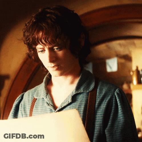 A Young Man In A Blue Shirt Is Looking At A Piece Of Paper GIF