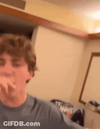A Young Man In A Blue Shirt Is Making A Face GIF