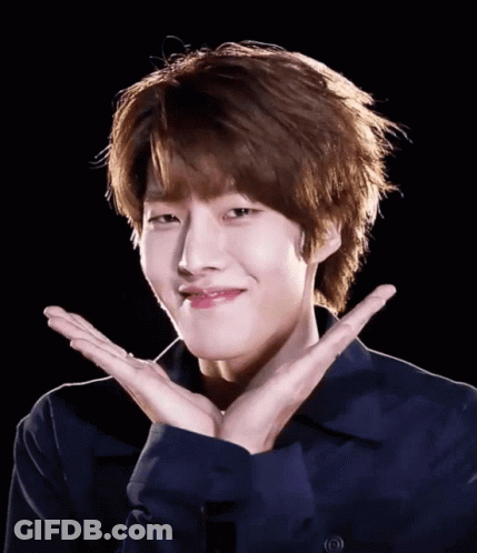 A Young Man In A Blue Shirt Is Making A Face With His Hands GIF