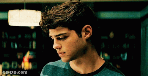 A Young Man In A Blue Striped Shirt Looks Down GIF