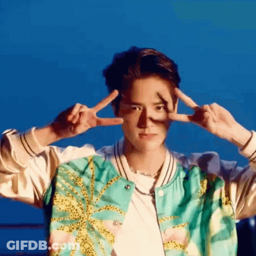 A Young Man In A Bomber Jacket Is Making A Peace Sign With His Hands . GIF